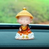 Tượng chú tiểu gật đầu đội nón áo cam cưỡi mây