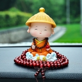 Tượng chú tiểu gật đầu đội nón áo cam cưỡi mây