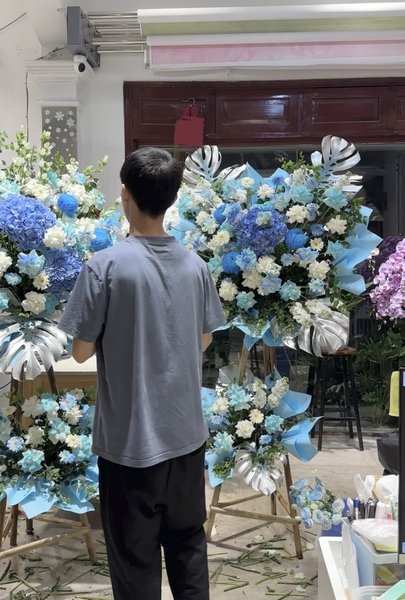 Florist tại Elise Flowers thực hiện sản phẩm hoa chúc mừng khai trương vào buổi tối.