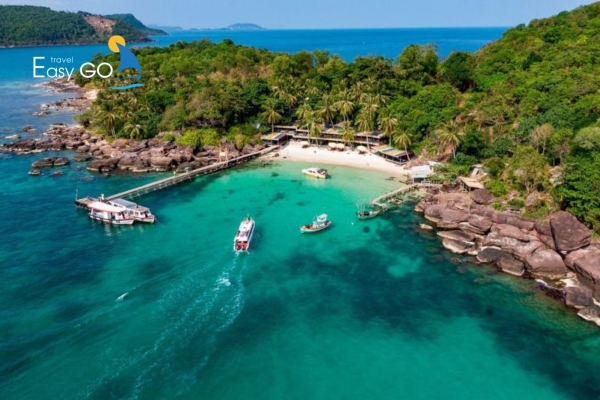 Bãi biển trong xanh với thuyền nhỏ neo đậu yên bình.