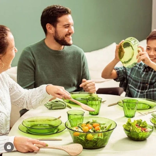 gia đình dùng bữa với bộ bát đĩa thủy tinh màu xanh lá cây và salad tươi