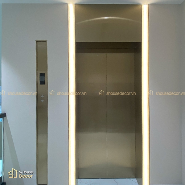 Các chi tiết line inox mảnh giúp khu vực thang máy sắc nét hơn mà không tạo cảm giác nặng thị giác.