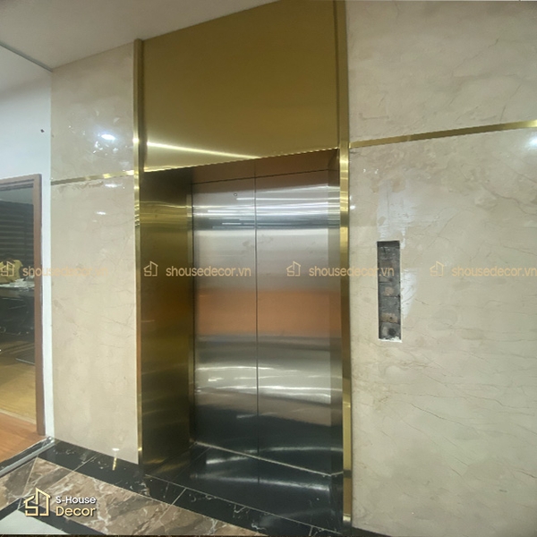 Khung bao inox vàng giúp khu vực thang máy sáng và gọn không gian hơn.
