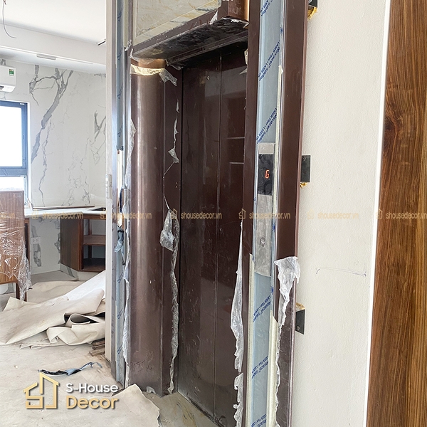 Cua-thang-may-sau-khi-op-khung-inox-ban-rong