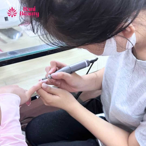 Thợ nail điều chỉnh tốc độ máy mài nail ít nóng