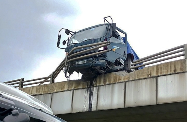 Ôtô húc văng lan can cầu vượt