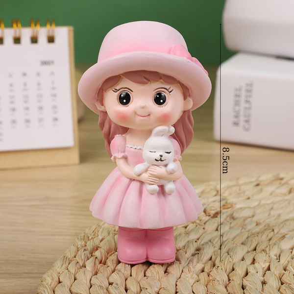 Bé gái đứng MŨ HỒNG ôm thỏ SỨ