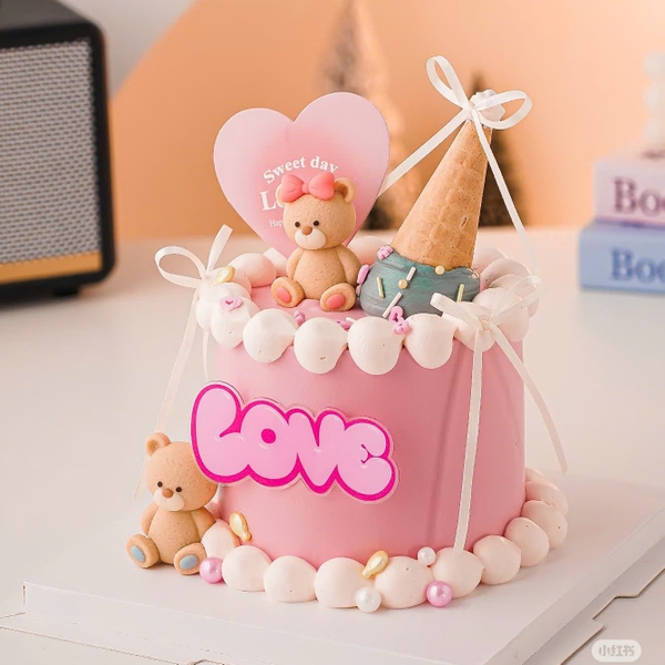 Tượng nhựa -gấu màu vàng nâu cài nơ hồng (bàn chân hồng).