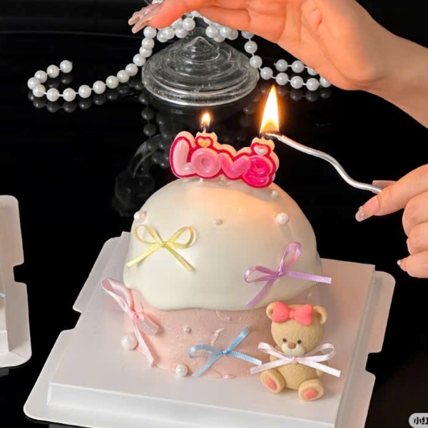 Tượng nhựa -gấu màu vàng nâu cài nơ hồng (bàn chân hồng).