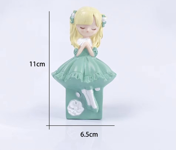 Tượng em bé tóc vàng váy xanh ngọc.