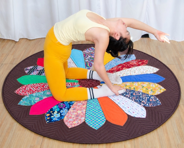 A girl is practicing yoga on the 1.5-meter Daisy Round Rug