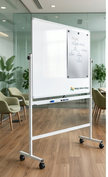 Bảng từ trắng 2 mặt có chân di động Nhật Minh Vina, khung nhôm chắc chắn, có bánh xe, đặt trong văn phòng hiện đại với ghế sofa và cây xanh.