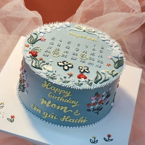 Bánh kem trang trí hoa và tờ lịch sinh nhật mẹ và bé