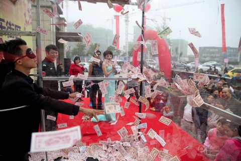 Trung Quốc: Đại gia bất động sản ném tiền cho mọi người bắt