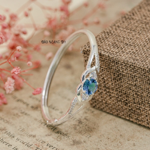 Vòng tay bé gái Mặt vòng hình 2 trái tim được gắn kết với nhau bởi viên đá xanh da trời V2409110005