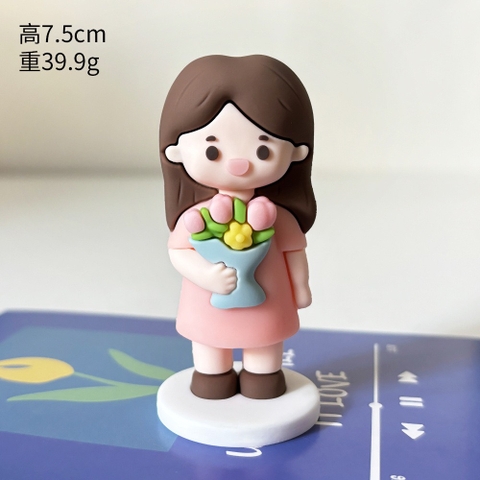 Tượng silicon -cô giáo váy hồng ôm hoa.