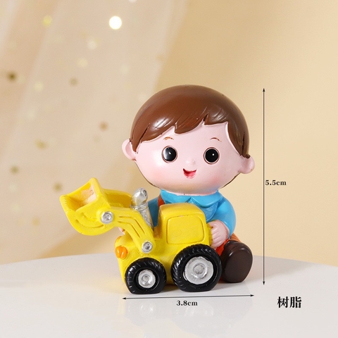 Tượng sứ bé trai máy xúc (áo xanh, quần cam).