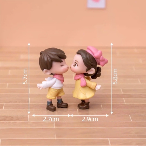 Đôi em bé nhựa đặc - váy vàng, quần vàng, nơ hồng, giày đen.