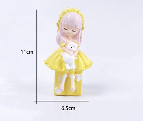 Tượng em bé tóc hồng váy vàng (ôm gấu).