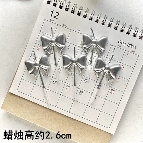 Vỉ 5 cây nến hình nơ màu BẠC.
