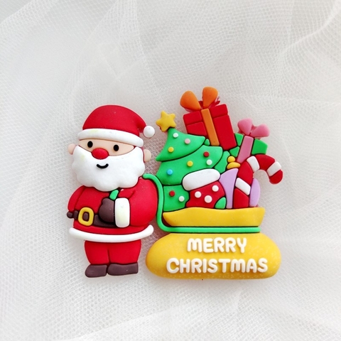 Tượng nhựa dẻo-Ông già noel đeo túi quà màu vàng có chữ XMAS trắng.