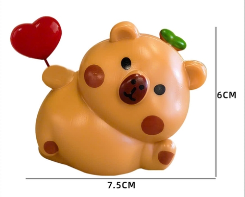 Tượng capybara nhựa cầm trái tim đỏ.