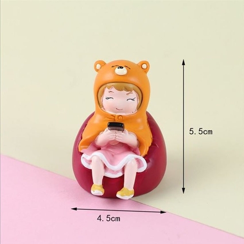 Bé gái ngồi cầm điện thoại