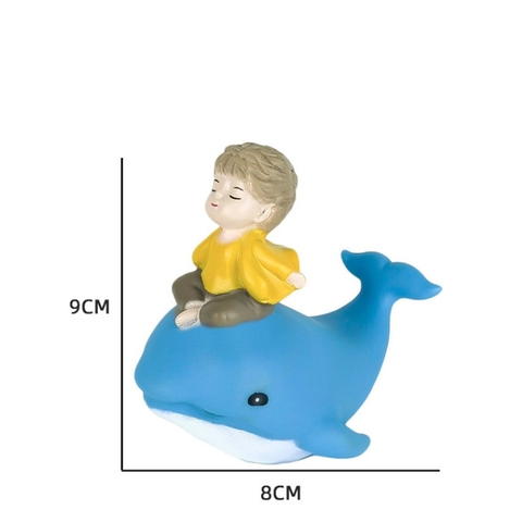 Bé trai ngồi cá voi