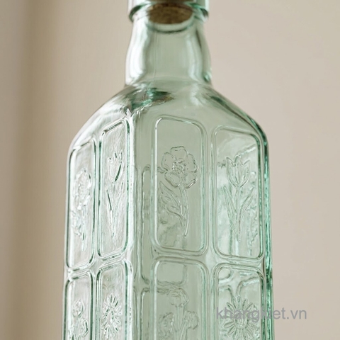 Cận cảnh thân chai thủy tinh vuông nút bần C.H Fiori 500ml với họa tiết hoa dập nổi tinh tế trên nền thủy tinh xanh nhạt