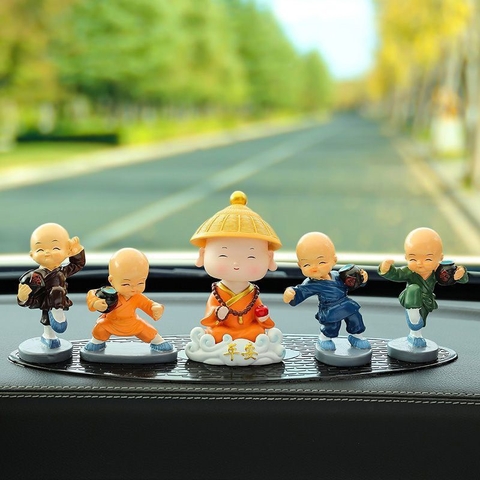 Tượng chú tiểu gật đầu đội nón áo cam cưỡi mây
