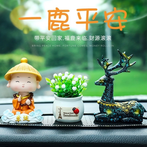 Tượng chú tiểu gật đầu đội nón áo cam cưỡi mây