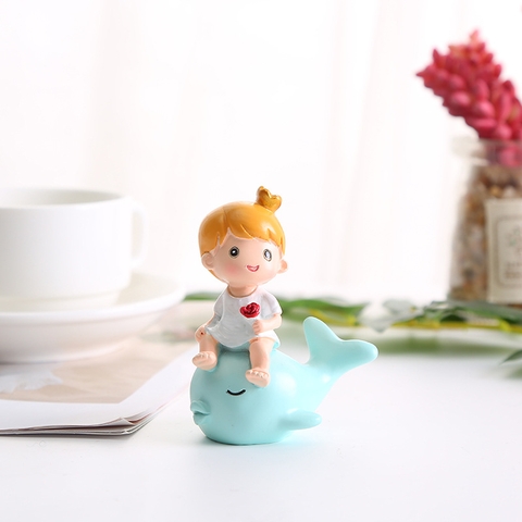 Đồ chơi trang trí em bé cưỡi cá heo xanh