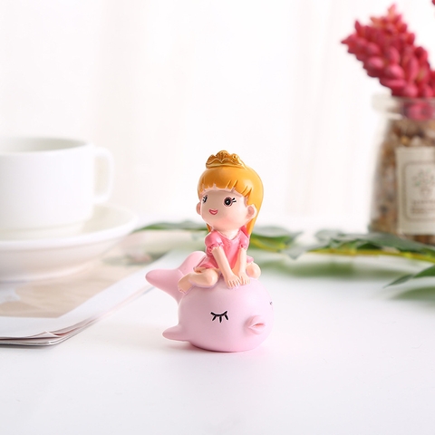 Đồ chơi trang trí em bé cưỡi cá heo hồng