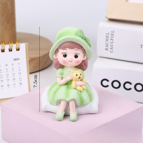 Bé gái ngồi MŨ XANH ôm GẤU SỨ