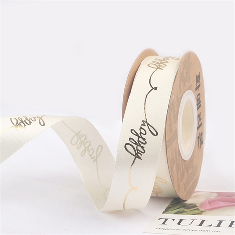 Rb lụa chữ happy nghiêng ép nhũ vàng khổ 2,5cm*22m MÀU NGÀ