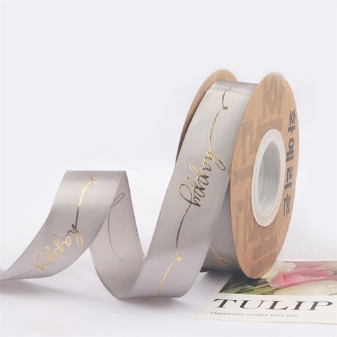 Rb lụa chữ happy nghiêng ép nhũ vàng khổ 2,5cm*22m MÀU GHI