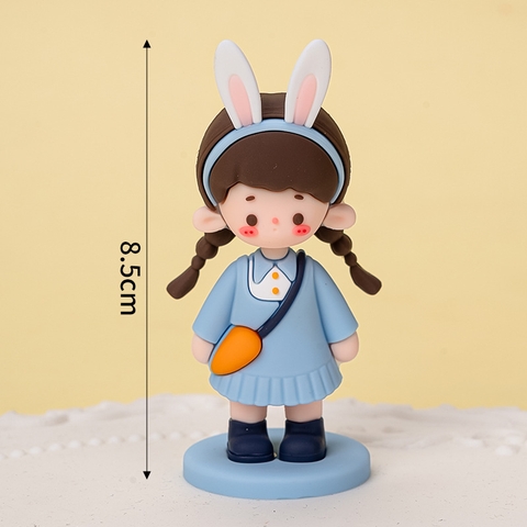 Bé gái váy xanh túi cam bờm thỏ