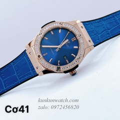 Đồng Hồ Nam Hublot Automatic Viền Đá Vuông Dây Da Vân Silicone Xanh Rose Gold 42mm
