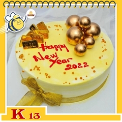 Bánh kem tặng khách hàng K13 nền vàng nhạt thắt nơ và những phụ kiện vàng bạc sang trọng sung túc