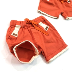 Quần short bé trai linen màu cam đính nút