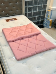 Nệm lụa mát Tencel đa năng gấp gọn ByGu màu hồng được gấp trên nệm lớn