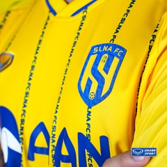 Áo SLNA 2023 Grand Sport 011019 Vàng