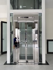 Thang Máy Khung Thép Vách Kính Inox Gương Trắng
