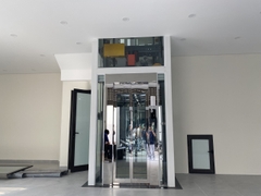 Thang Máy Khung Thép Vách Kính Inox Gương Trắng