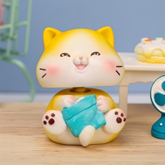 Trang trí sứ con mèo vàng cười giơ chân cầm gối xanh (cổ lò xo)