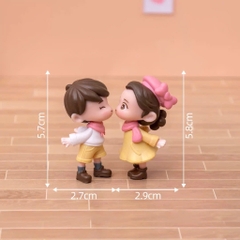 Đôi em bé nhựa đặc - váy vàng, quần vàng, nơ hồng, giày đen.
