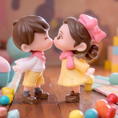 Đôi em bé nhựa đặc - váy vàng, quần vàng, nơ hồng, giày đen.