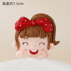 Tượng silicon-bé gái cài nơ đỏ giơ 2 tay lên má.treo