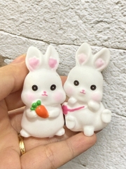 Đôi thỏ nhựa trắng (cầm carrot và đeo túi hồng).