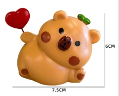 Tượng capybara nhựa cầm trái tim đỏ.